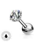 A silver-toned labret piercing barbell with a large, clear, faceted round gemstone on the top and a polished ball end on the bottom. A circular badge in the bottom-left corner highlights the product's skin-safe, waterproof, and tarnish-free qualities.