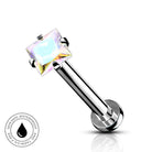A silver-toned labret piercing barbell with a square iridescent clear gemstone, shown on a white background with a small circular 'Skin Safe Waterproof' badge in the lower left.