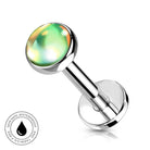 A silver-toned labret piercing barbell with a round, iridescent green and yellow top, shown on a white background with a small circular 'Skin Safe Waterproof' badge in the lower-left corner.
