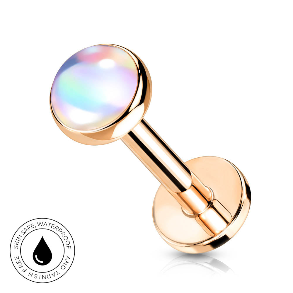 Rose gold labret piercing stud with a round iridescent opal-like top, shown on a white background with a small circular skin-safe waterproof badge in the lower left corner.