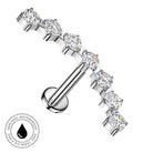 A silver-toned labret piercing barbell featuring seven clear, round-cut cubic zirconia stones in a row. A circular badge in the bottom-left corner highlights its 'Skin Safe, Waterproof' and 'Tarnish Free' qualities.