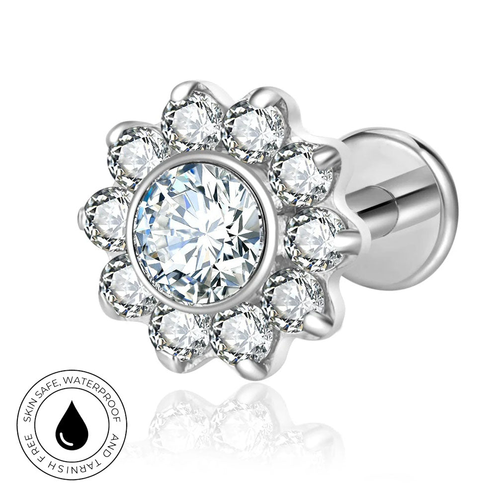 Silver-toned flower-shaped stud earring with a large clear round center stone and surrounding clear petal stones, shown on a white background with a circular skin-safe waterproof badge.