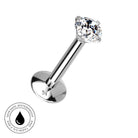 A silver-toned labret piercing barbell with a clear faceted gemstone, shown on a plain white background with a circular 'Skin Safe Waterproof' badge in the lower-left corner.