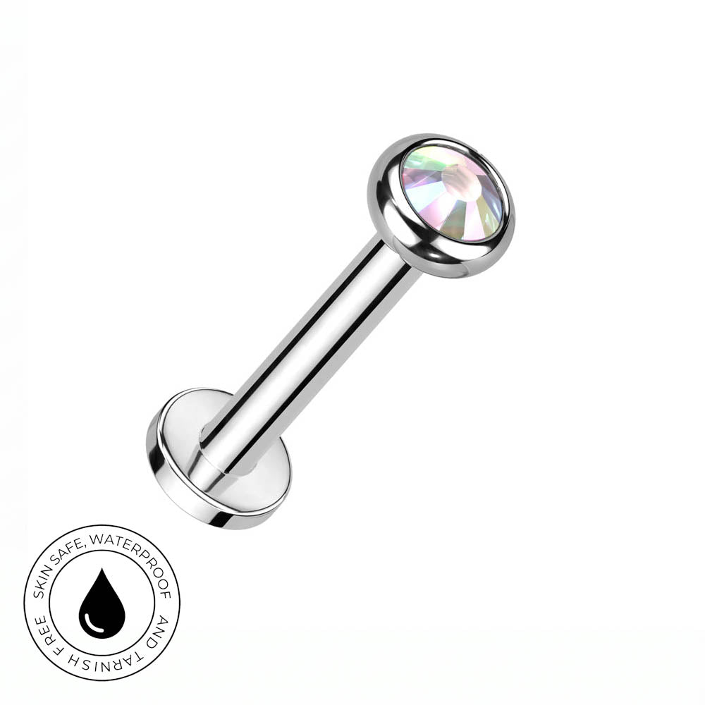 A silver-toned labret piercing barbell with a faceted iridescent clear gemstone ball end, shown on a plain white background with a circular 'Skin Safe Waterproof' badge in the lower-left corner.