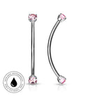Two silver-toned body jewelry piercings with pink gemstones, shown on a white background. One is a straight barbell and the other is a curved labret.