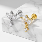 Two pairs of butterfly stud earrings with marquise-cut clear stones and dangling round clear stones, shown on a white marble block. One pair is silver-toned and the other is gold-toned.