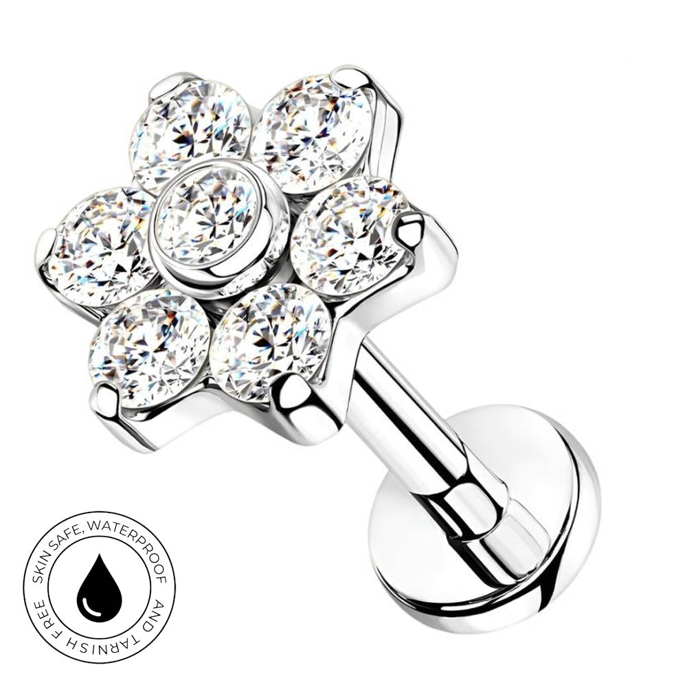 A silver-toned flower-shaped piercing stud with six clear faceted gemstones, shown on a white background with a circular 'SkinSafe Waterproof' badge in the lower-left corner.