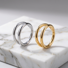 Two double-hoop earrings, one polished silver-tone and one polished yellow gold-tone, displayed side-by-side on a white marble block.