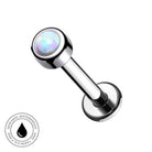 A chrome-plated labret piercing barbell with a round iridescent opal gemstone in the top ball, shown on a plain white background with a circular 'Skin Safe Waterproof' badge in the bottom-left corner.