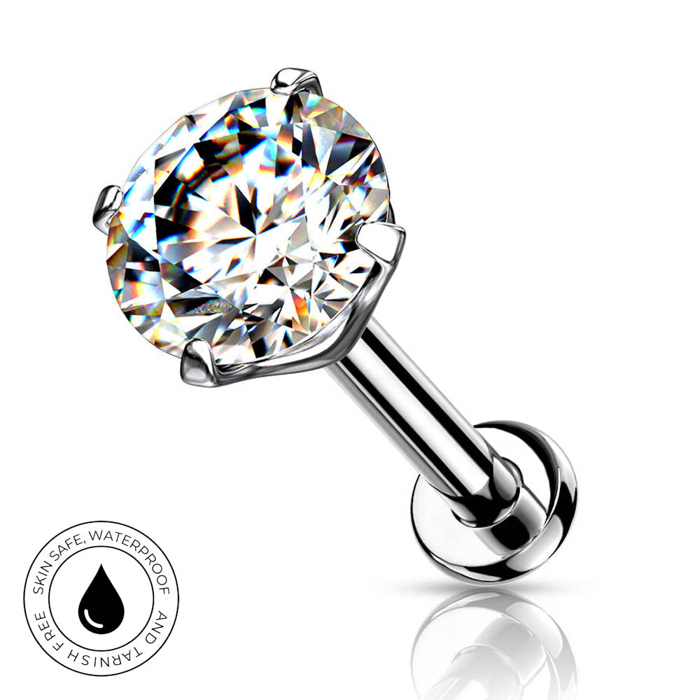 A silver-toned labret piercing barbell with a large round brilliant-cut clear gemstone in a prong setting, shown on a white background with a reflection below and a small circular 'Skin Safe Waterproof' badge in the lower left.
