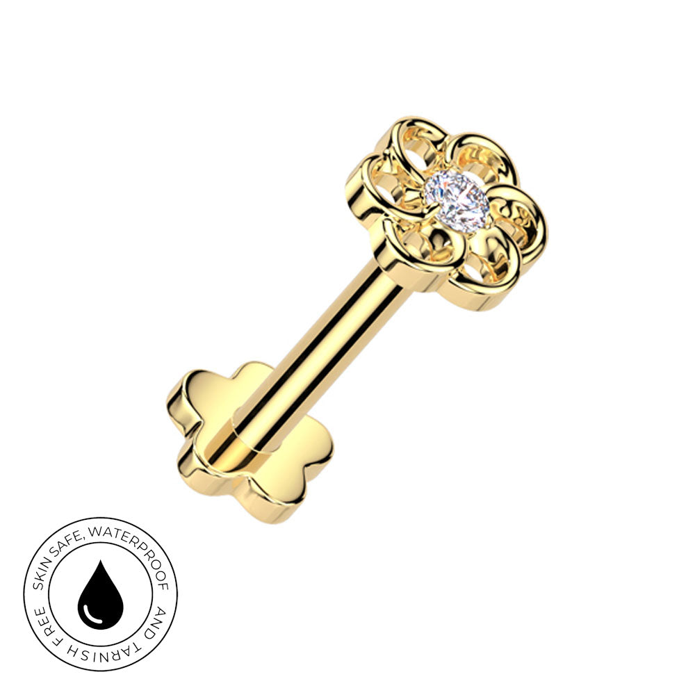 A gold flower-shaped labret stud with a clear central gemstone, shown on a white background with a circular 'Skin Safe Waterproof' badge in the lower-left corner.