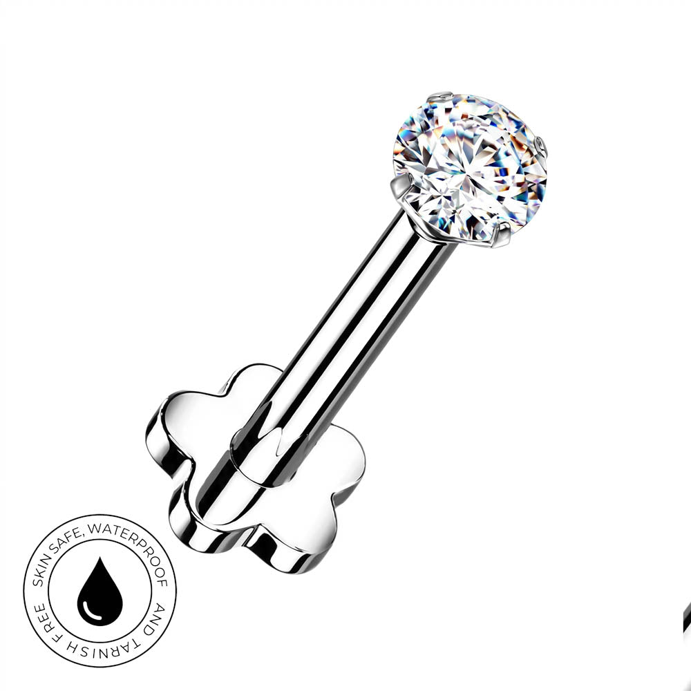 A silver-toned flat-back labret piercing barbell with a clear round-cut gemstone, shown on a white background with a circular 'Skin Safe Waterproof' badge in the lower-left corner.