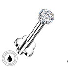 A silver-toned flat-back labret piercing barbell with a clear round-cut gemstone, shown on a white background with a circular 'Skin Safe Waterproof' badge in the lower-left corner.