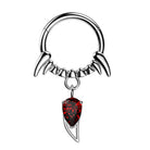 Silver septum ring with red gemstone on a white background