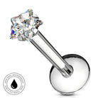 A silver-toned labret piercing barbell with a clear, multi-faceted star-shaped gemstone. A circular badge in the bottom-left corner highlights the product's 'Skin Safe Waterproof' feature.