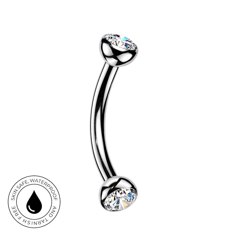 A curved barbell piercing jewelry piece with clear faceted gemstones on both ends, shown on a plain white background with a circular 'Skin Safe Waterproof' badge in the lower left corner.