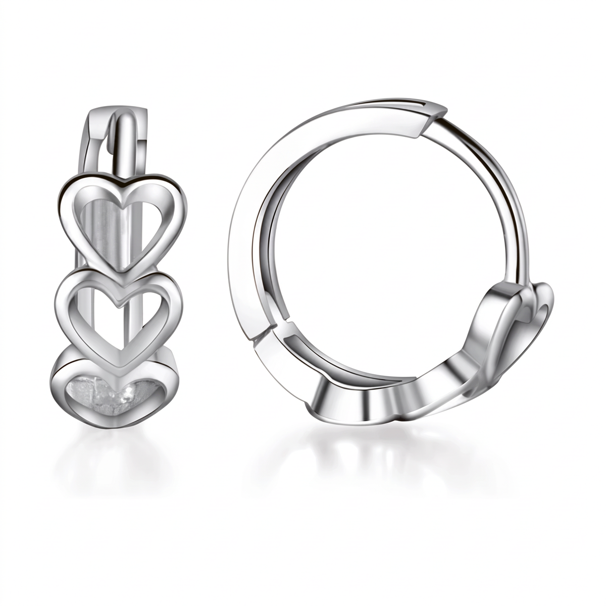 A pair of polished silver huggie hoop earrings with stacked heart charms, shown on a clean white background with soft reflections.