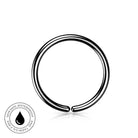A polished stainless steel nose ring with a tribe design, shown on a white background with a small circular skin-safe waterproof badge in the bottom-left corner.