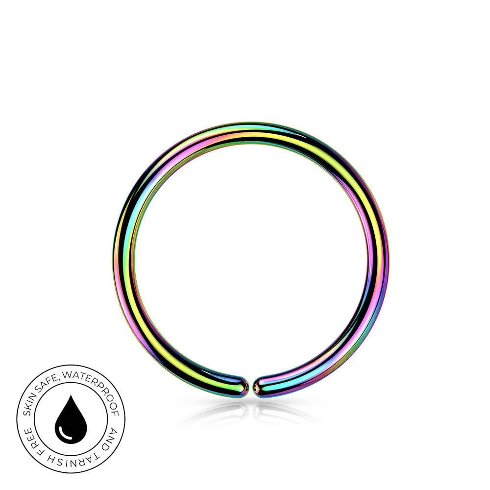 An iridescent rainbow metallic ring-shaped body jewelry piece on a white background, with a circular 'Skin Safe Waterproof' badge in the bottom-left corner.