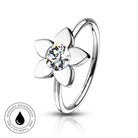 A silver-toned flower-shaped ring with a clear round-cut center stone, shown on a white background with a small circular 'skin-safe waterproof' badge in the lower left corner.