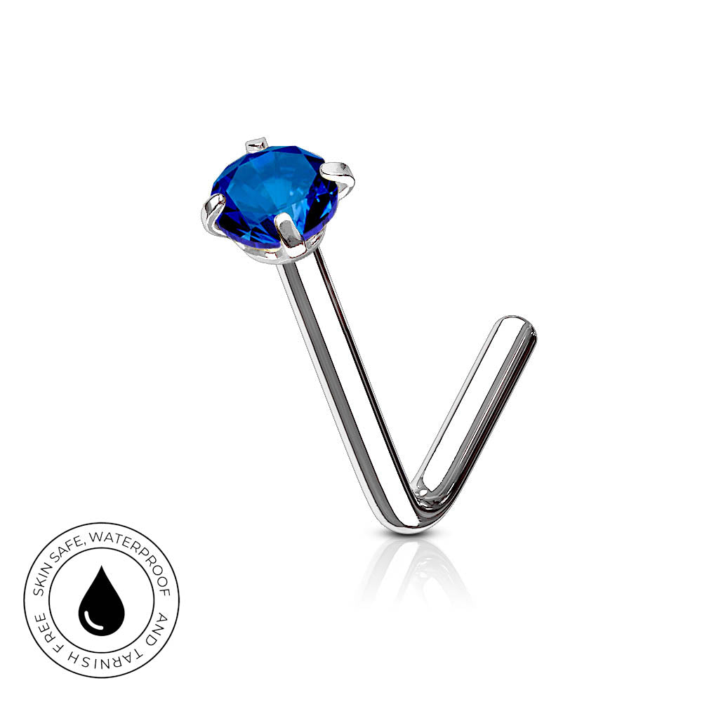 A silver-toned labret piercing stud with a round-cut deep blue gemstone, shown on a clean white background with a reflection. A circular 'Skin Safe Waterproof' badge is visible in the bottom-left corner.