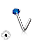 A silver-toned labret piercing stud with a round-cut deep blue gemstone, shown on a clean white background with a reflection. A circular 'Skin Safe Waterproof' badge is visible in the bottom-left corner.