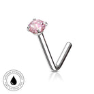 A silver-toned labret piercing stud with a round pink gemstone, shown on a white background with a small circular 'skin-safe waterproof' badge in the lower-left corner.