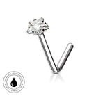 A silver-toned curved barbell nose ring with a flower-shaped clear gemstone, shown on a white background with a small circular skin-safe waterproof badge in the lower left corner.