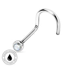 A curved silver-toned labret piercing stud with a clear faceted gemstone in a bezel setting, shown on a white background with a circular 'Skin Safe Waterproof' badge in the lower-left corner.
