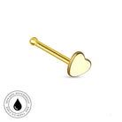 A gold-colored labret stud earring with a heart-shaped face, shown on a plain white background with a circular 'Skin Safe Waterproof' certification badge in the bottom-left corner.