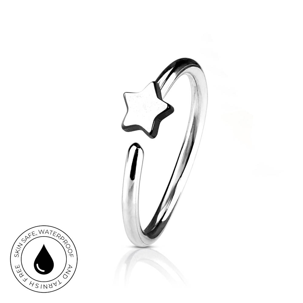 A silver-toned open ring band featuring a small star-shaped charm, shown on a clean white background with a subtle reflection. A circular 'Skin Safe Waterproof' badge is visible in the bottom-left corner.
