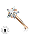 A rose gold nose stud featuring a clear, faceted six-pointed star gemstone on a plain white background with a small circular 'Skin Safe Waterproof' badge in the lower-left corner.
