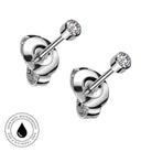 Two silver-toned labret stud earrings with round bezel-set clear gemstones, shown on a white background with a circular 'Skin Safe Waterproof' badge in the lower left corner.
