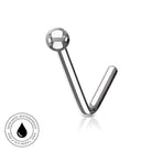 A curved stainless steel labret piercing stud with a polished ball top, shown on a white background with a small circular skin-safe waterproof badge in the lower-left corner.