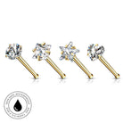 Four gold-plated nose studs with clear gemstones in star, square, round, and heart shapes, displayed on a white background with a circular 'Skin Safe Waterproof' badge in the bottom-left corner.