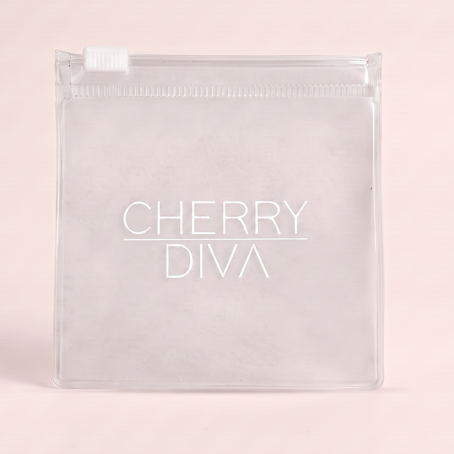 A clear plastic zippered pouch with a white zipper tab and the brand name 'CHERRY DIVA' printed in white on the front, set against a solid pale pink background.