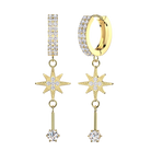 A pair of gold huggie hoop earrings with pavé-set clear stones, a vertical bar of stones, and dangling starburst charms with a hanging rod ending in a round clear stone, shown on a plain white background.