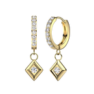 A pair of gold hoop and drop earrings with clear gemstones, shown on a plain white background. One earring is a hoop with a vertical bar of round-cut stones, and the other is a huggie hoop with a diamond-shaped drop set with a central round-cut stone.