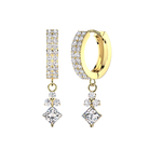 A pair of gold huggie hoop earrings with pavé-set clear gemstones, featuring a vertical rectangular drop on one earring and a diamond-shaped drop on the other, shown against a plain white background.