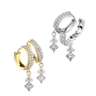 Two pairs of huggie hoop earrings with dangling princess-cut diamond charms, shown in yellow gold and silver-tone metal on a plain white background.