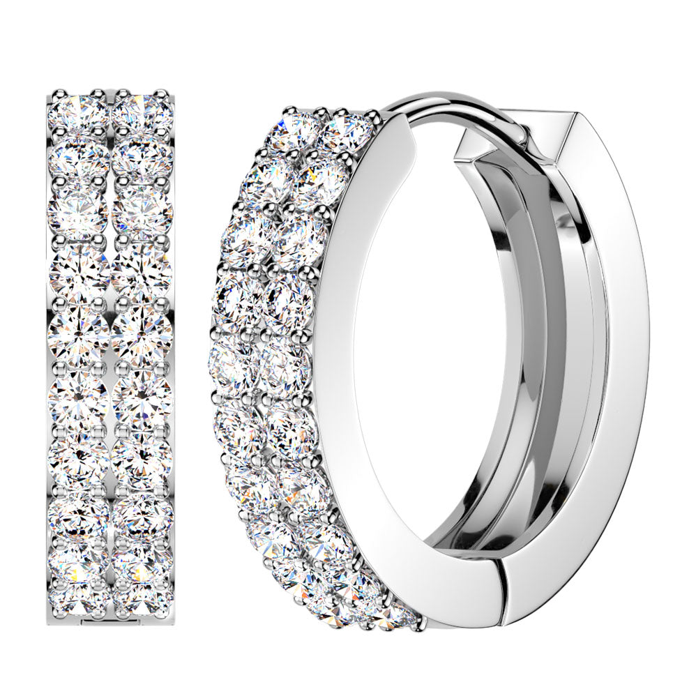 A pair of silver-toned huggie hoop earrings paved with round clear stones, shown on a plain white background with one earring viewed from the side and the other from the front.