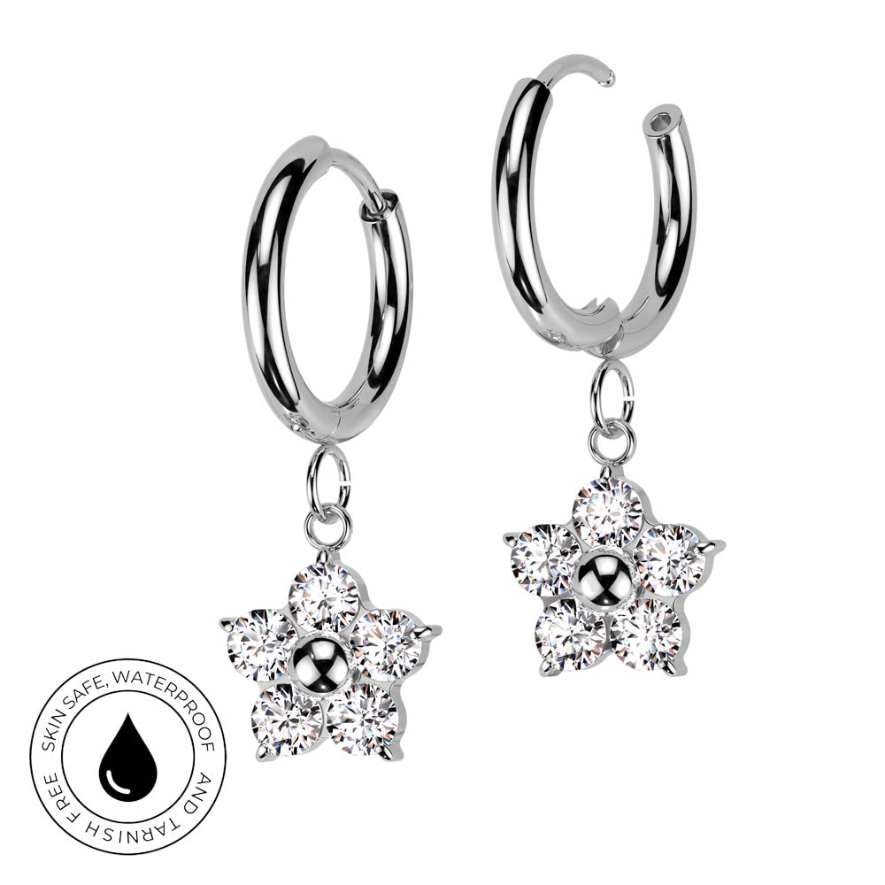 A pair of silver hoop earrings with dangling flower-shaped clusters of clear crystals, shown on a white background with a circular 'Skin Safe Waterproof' badge in the lower left corner.