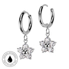 A pair of silver hoop earrings with dangling flower-shaped clusters of clear crystals, shown on a white background with a circular 'Skin Safe Waterproof' badge in the lower left corner.