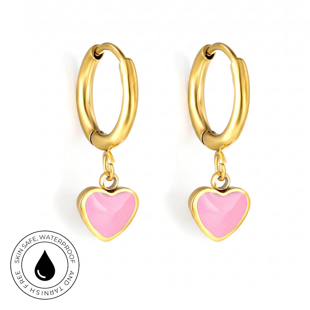 A pair of gold hoop earrings with dangling pink heart charms, shown on a plain white background with a circular 'Skin Safe Waterproof and Tarnish Free' badge in the bottom-left corner.
