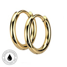 Two polished gold hoop earrings shown on a plain white background, with a circular inset badge at the lower left reading 'Skin Safe, Waterproof, and Tarnish Free' with a droplet icon.