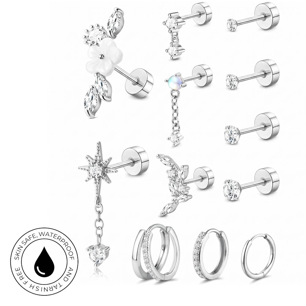 A set of silver-colored stud earrings and hoop earrings with clear crystals, displayed on a clean white background. The collection includes various designs such as a flower with leaves, a dangling star with a heart, a crescent moon, and multiple styles of hoop earrings, some adorned with small crystals.