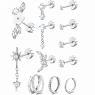 A set of silver-toned ear piercings and hoop earrings displayed on a clean white background. The collection includes floral stud earrings, dangling star and fairy charms, multiple straight barbell studs with clear stones, and several silver hoop styles, some adorned with small clear crystals.