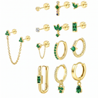 A set of gold-colored stud earrings and ear cuffs with green gemstone accents, displayed on a clean white background.