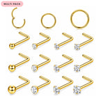 A multi-pack of gold-colored nose studs and cartilage piercings arranged on a white background. The set includes curved barbell studs with ball ends, straight barbell studs with clear round gemstones, and hoop-style cartilage piercings.