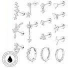 A collection of silver-toned stud earrings and hoop earrings with clear stones, arranged on a white background. The set includes various shapes such as stars, leaves, hearts, and geometric designs.